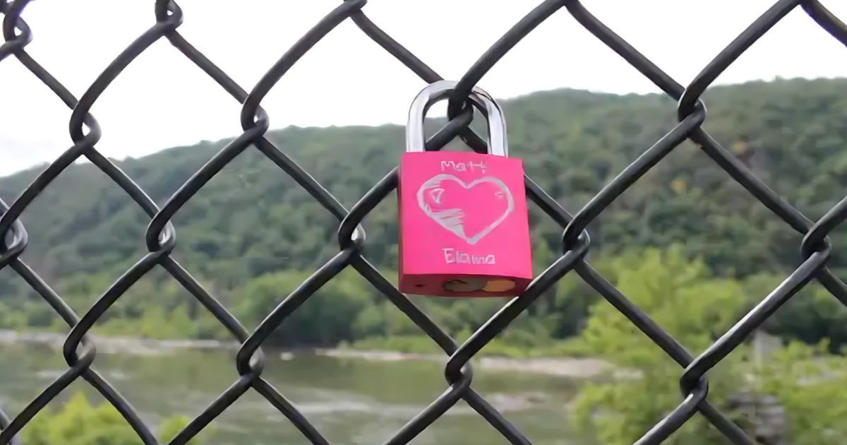 A pink Love Lock adorns the chain link fence on a bridge that crosses the Potomac River near Maryland Heights and Harpers Ferry, WV.